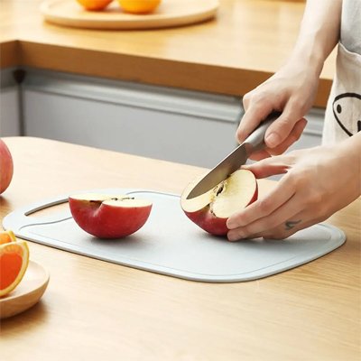 Planche à découper coupe une pomme sur la planche